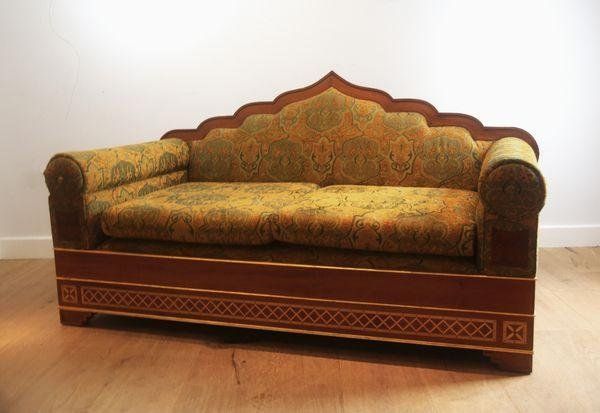 A HARDWOOD TWO-SEATER SOFA WITH ARCHED MORESQUE BACK RAILS