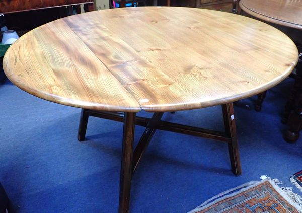 ERCOL: AN OVAL PARTLY STRIPPED DROP-LEAF DINING TABLE