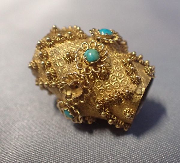 A GOLD BEAD WITH TURQUOISE BEADS