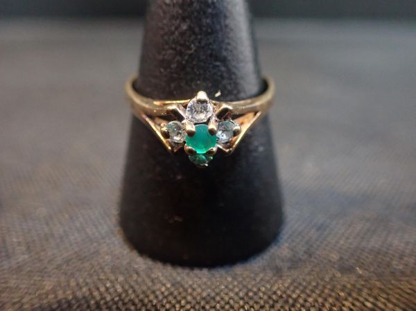 A 9CT GOLD WHITE AND GREEN STONE FLOWERHEAD RING