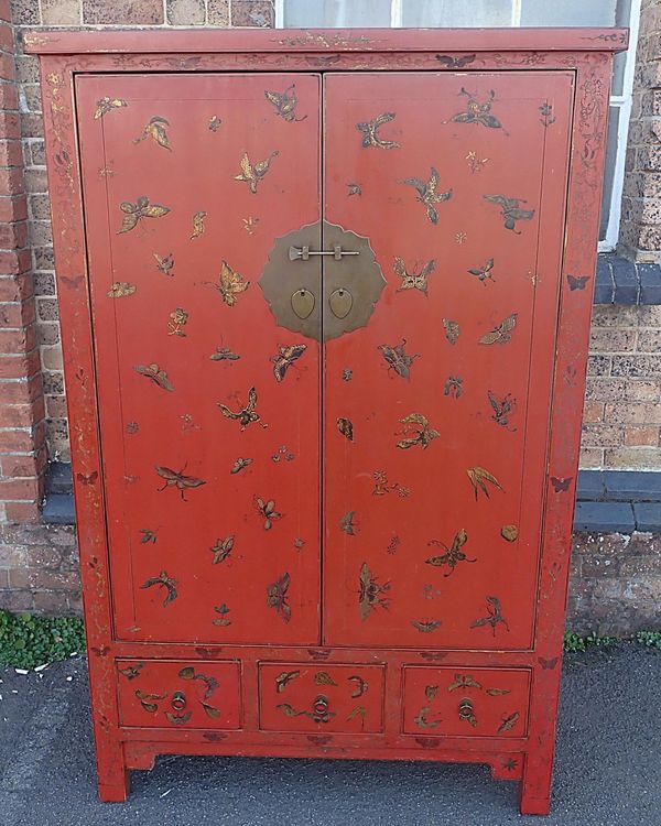 A CHINESE RED PAINTED CABINET DECORATED WITH PAINTED AND GILT BUTTERFLIES