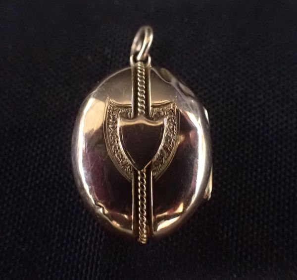 A GOLD COLOURED METAL OVAL LOCKET