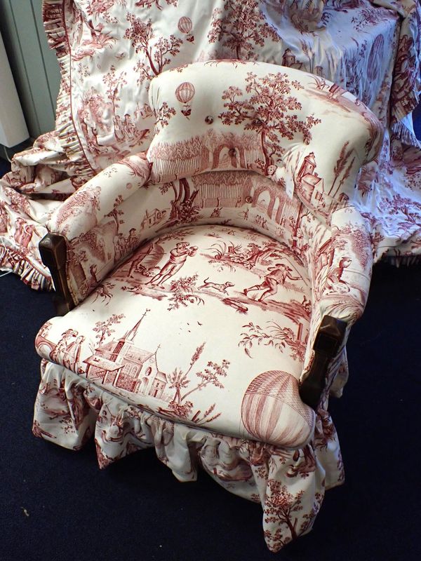 AN EDWARDIAN TUB CHAIR UPHOLSTERED IN BALLOONING TOILE DE JOUY