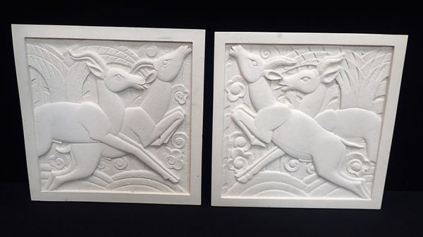 A PAIR OF ART DECO STYLE RESIN BAS-RELIEF PLAQUES
