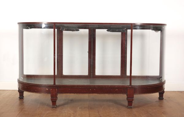 AN EDWARDIAN GLAZED MAHOGANY BOW FRONTED SHOP OR MUSEUM CABINET