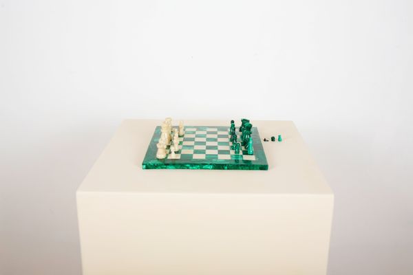 A MARBLE AND MALACITE INLAID CHESS BOARD WITH CHESS PIECES
