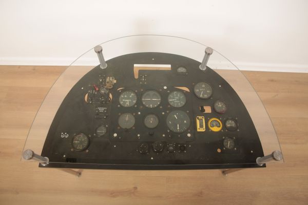 A COMPOSITE AIRCRAFT COCKPIT CONTROL PANEL CONVERTED TO A DEMI-LUNE TABLE