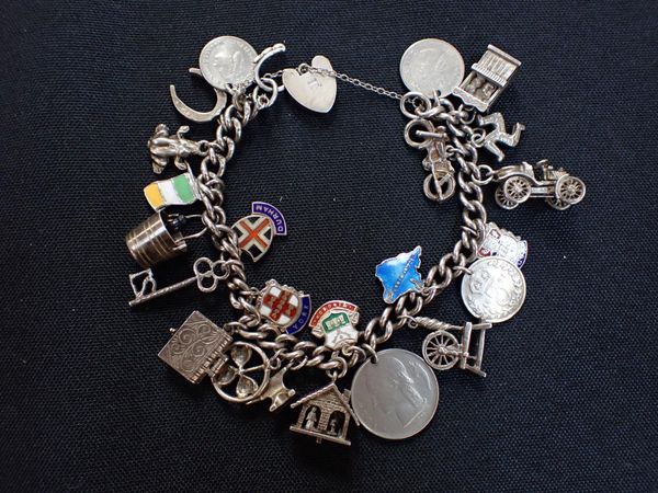 A WHITE METAL CHARM BRACELET, INDISTINCTLY MARKED