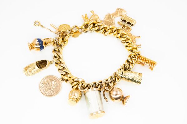 A GOLD CURB LINK CHARM BRACELET 15 charms