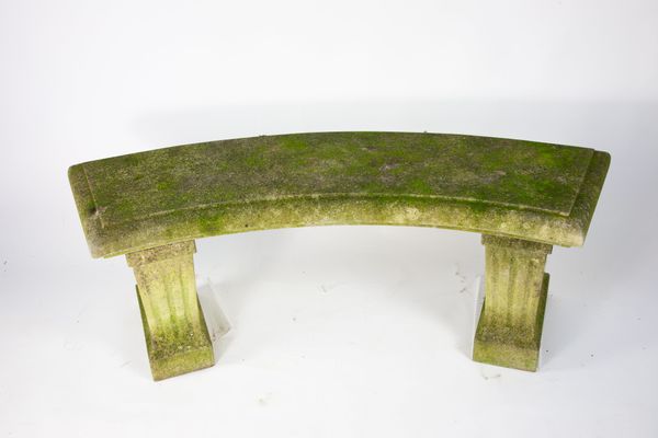 A curved limestone garden bench