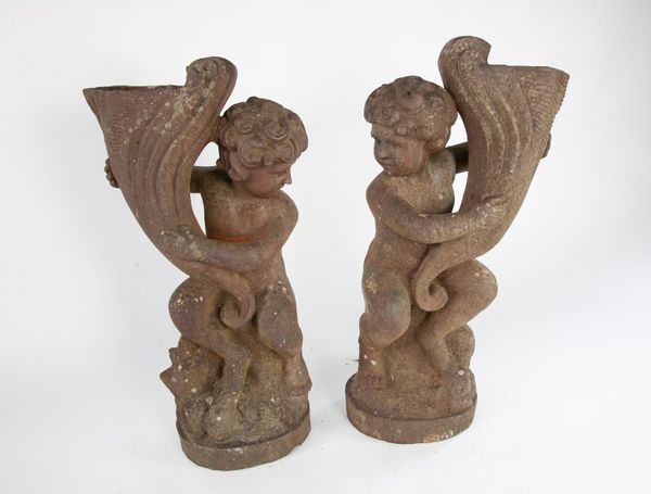 A pair of cast iron putti holding cornucopia