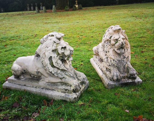A pair of composition stone lions 2nd half 20th century 54cm high by 73cm long