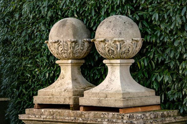 † A pair of Edwardian substantial carved Portland stone gate pier balls on bases circa 1900 104cm high, bases 66cm square