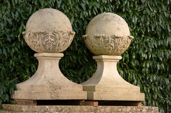 † A similar pair of carved Portland stone gate pier balls on bases 104cm high, bases 66cm square