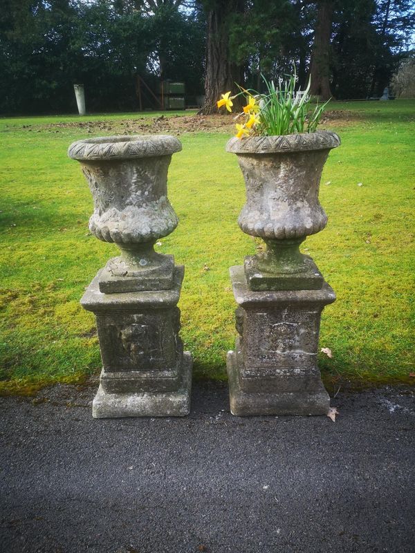 A pair of composition stone urns on pedestals 2nd half 20th century 90cm Part of the Late Dr Gerald Moore Collection of Paintings and Sculpture