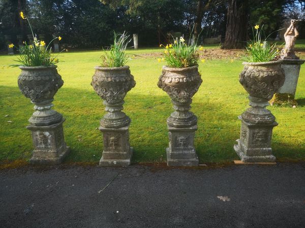 A set of four composition stone urns on pedestals 2nd half 20th century 110cm high Part of the Late Dr Gerald Moore Collection of Paintings and...