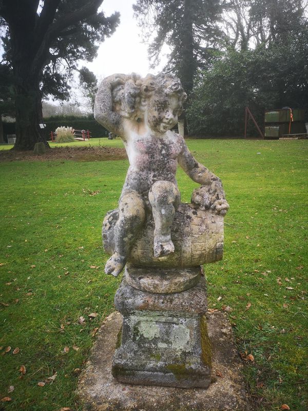 A composition stone figure of the young Bacchus perched on a wine barrel 2nd half 20th century 71cm  From a Private Collection in Ireland, see lot...
