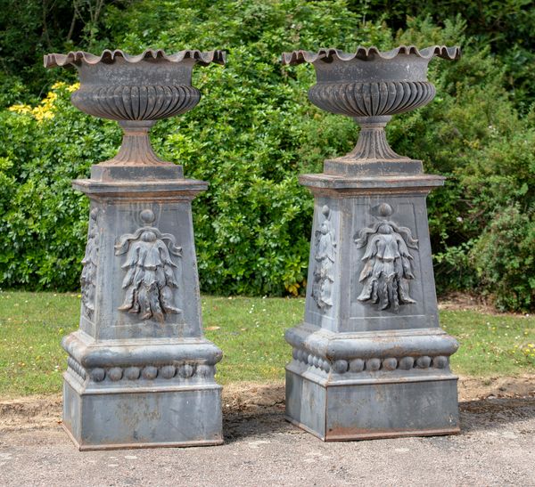 A large and impressive pair of cast iron urns on pedestals French, circa 1860 167cm high by 78cm diameter