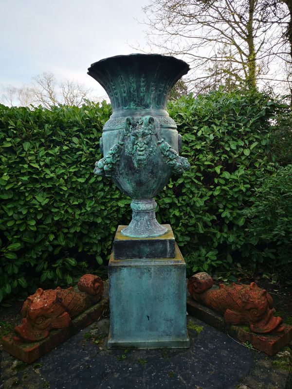 A patinated fibreglass urn on pedestal  the urn 150cm high; overall height 220cm Provenance: From a private garden in Totteridge, North London