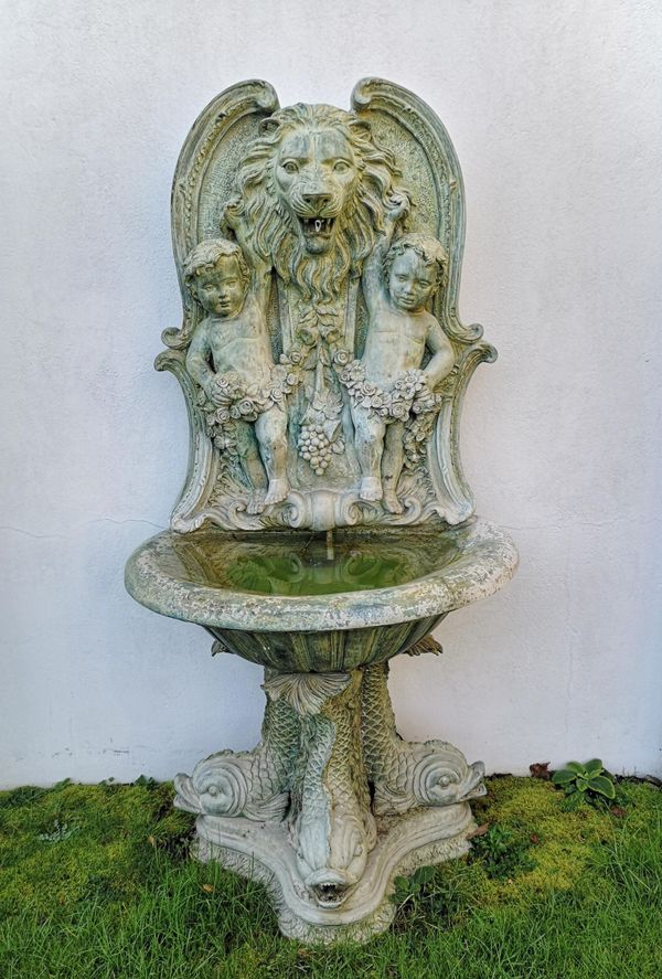 A bronze wall fountain last quarter 20th century  lion‘s mouth and dolphins plumbed for water 185cm high; bowl width 98cm Provenance: From a private...
