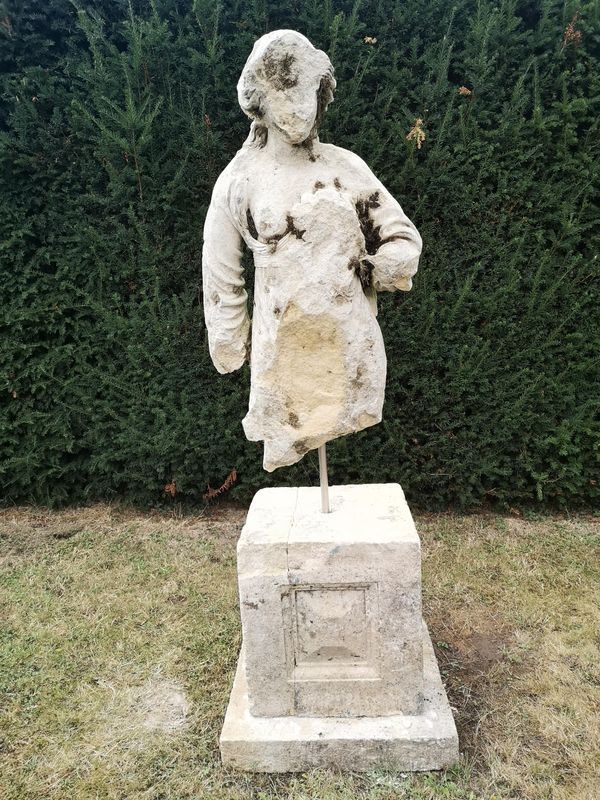 An early fragmentary carved stone torso of a woman on Cotswold stone pedestal 170cm high overall