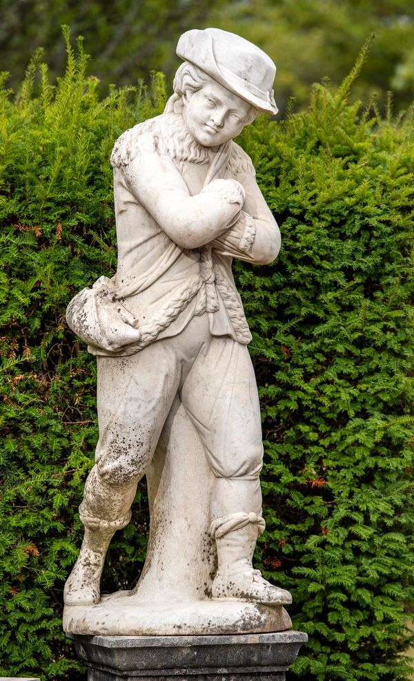 A white marble figure of a youth representing Winter probably Dutch, 18th century  warmly dressed in fur-lined breeches and hat, his arms clasped...