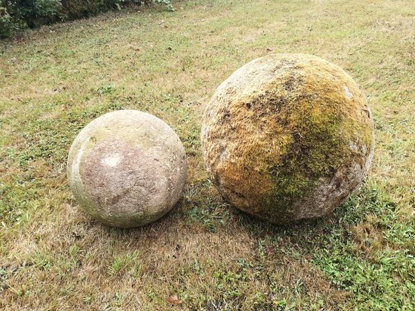 A substantial carved Cotswold stone ball 52cm diameter together with a smaller carved Cotswold stone ball, 37cm diameter