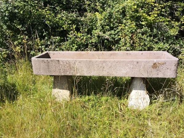 A carved sandstone rectangular trough raised on two staddlestone bases 88cm high by 214cm long by 61cm deep