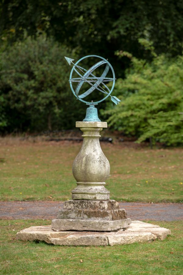 A carved Cotswold stone sundial pedestal on octagonal surround with later copper armillary sphere 176cm high