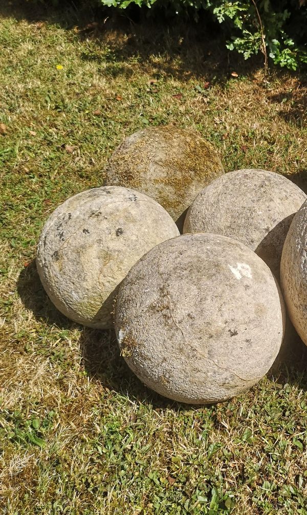 A set of four carved Cotswold stone balls 23cm diameter