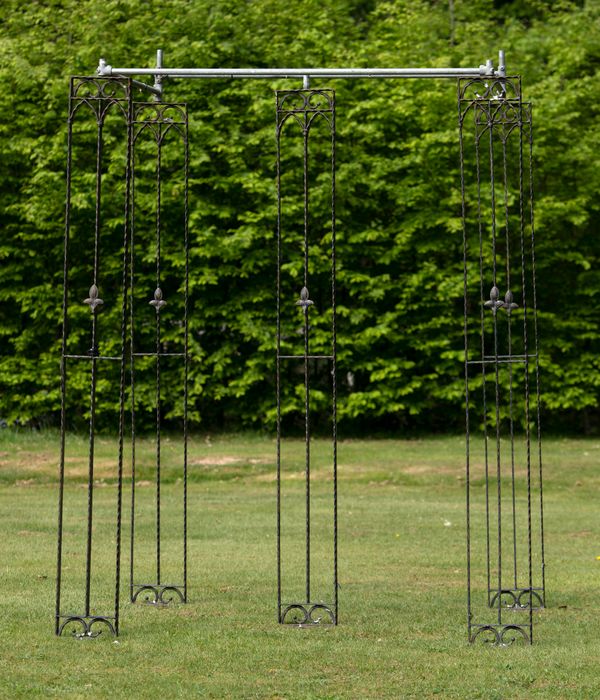 The components of a wrought iron pergola with five uprights 240cm high, together with a quantity of steel roofing poles   GE086 unsold lot fee to...