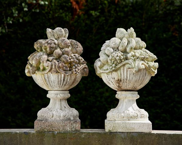 A similar pair of composition stone baskets of fruit