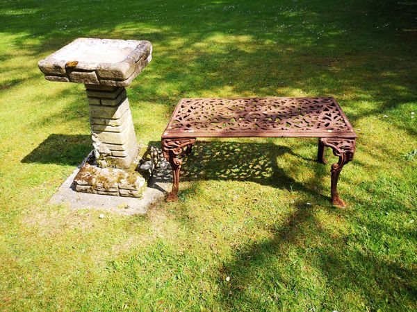 A cast iron rectangular table 2nd half 20th century  92cm wide, together with a composition stone bird bath, 80cm high