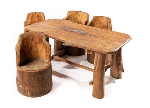 A carved hardwood table and four chairs by Bill Ayres the tabletop with applied copper sturgeon table 165cm long by 183cm wide Bill Ayres based in...