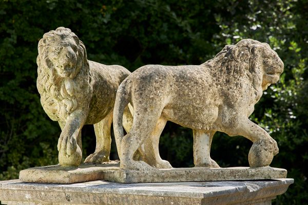 A pair of composition stone lions mid 20th century 56cm high by 74cm long