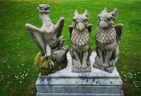 A pair of composition stone griffins 2nd half 20th century 55cm high, together with a composition stone dragon, 2nd half 20th century, 60cm high