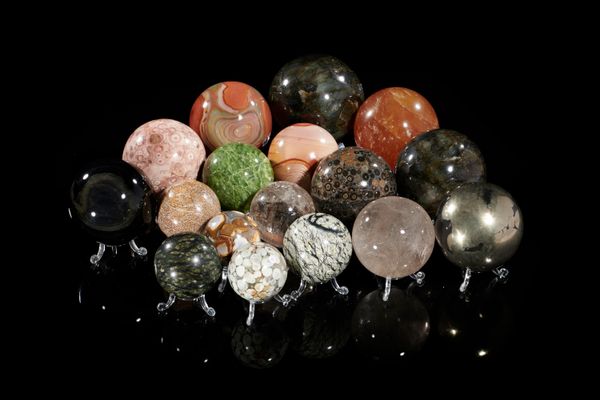 A large collection of mineral spheres including pyrite, obsidian, jasper, quartz, golden calcite, labradorite and Indian pudding stone the largest...