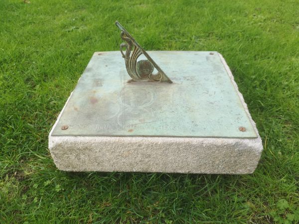 An Edwardian bronze square sundial plate early 20th century on carved limestone moulding 24cm high by 30cm square