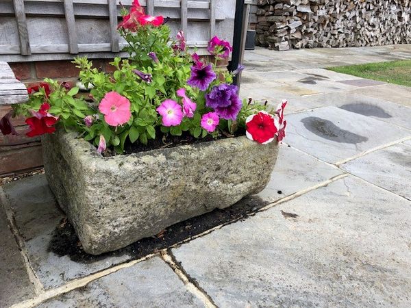 A carved stone trough 27cm high by 46cm wide by 59cm long (Flowers not included)