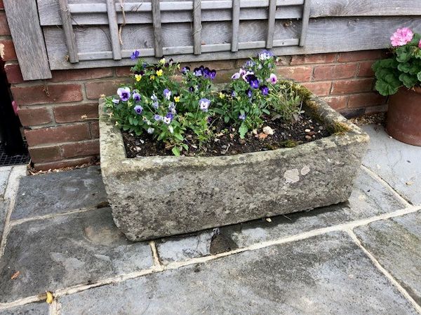 A carved stone trough 28cm high by 79cm long by 53cm deep (Flowers not included)