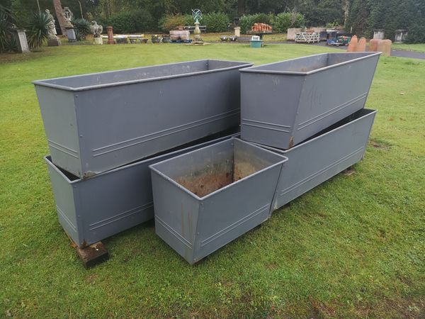 A collection of four galvanised metal rectangular planters modern  124cm long and a similar smaller planter, 63cm long