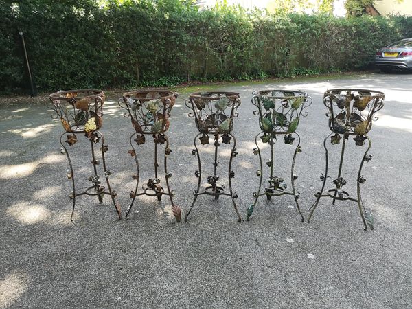 A set of three wrought iron jardiniere stands