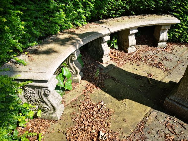 A composition stone curved bench