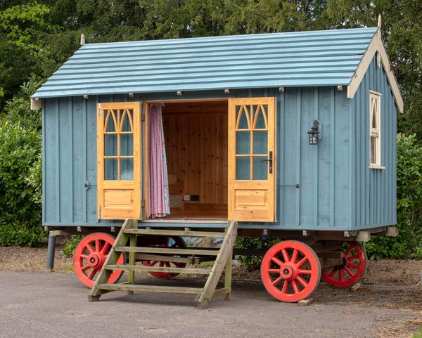 A wooden shepherds hut made by Red Sky, Norfolk in 2010 the wooden superstructure on oak frame with iron bounded wooden wheels, the interior with...