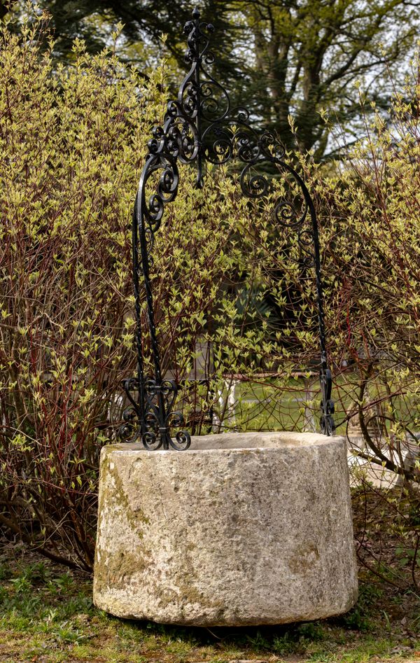 A carved stone wellhead French, 18th/19th century with later wrought iron overthrow 270cm high by 110cm diameter 