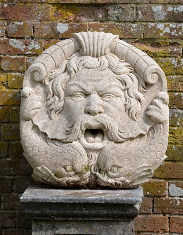 A carved limestone fountain mask of a bearded man and dolphins late 20th century mouth drilled for water  66cm high