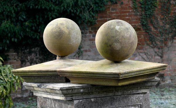 A pair of carved stone gate pier balls and caps late 19th century balls 30cm diameter, the caps 64cm square