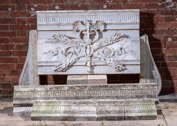 A carved Travertine marble frieze plaque 2nd half 19th century carved with thunderbolts and a caduceus flanked by a run of matching fruited frieze,...