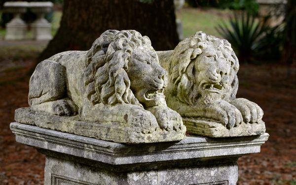 After Canova: A pair of carved limestone lions 20th century 77cm long