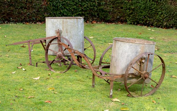 A wrought iron and galvanised zinc water bowser Edwardian 130cm long, together with another water bowser